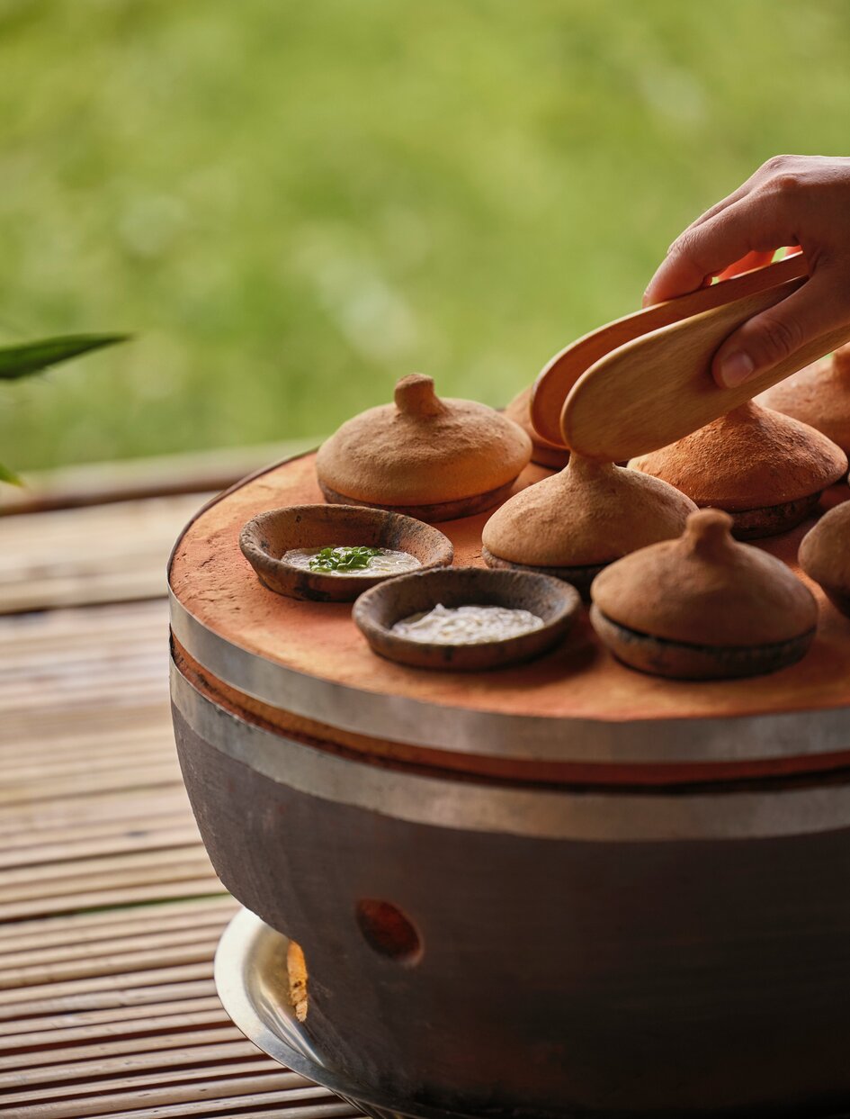 Afternoon tea bánh căn served on wooden board at Amanoi, Vietnam.