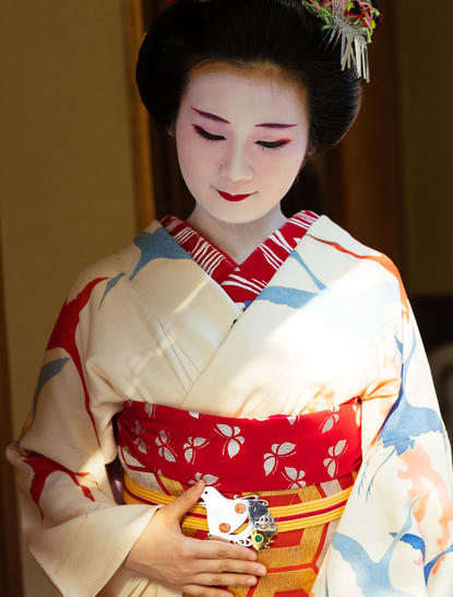 Woman in traditional Japanese kimono with red and white pattern at Aman Tokyo gallery.
