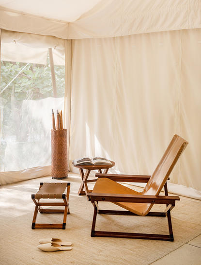 Wooden lounge chairs beside a window at Aman-i-Khas, with cream canvas walls.