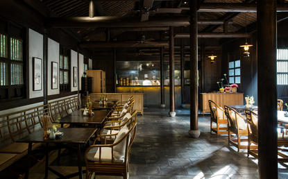 Amanfayun dining venue with wooden furniture, natural light from large windows, and traditional architectural details.