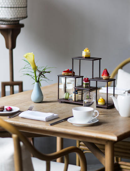 Wooden desk at Amanfayun with yellow flowers, candles, and decorative objects arranged thoughtfully.