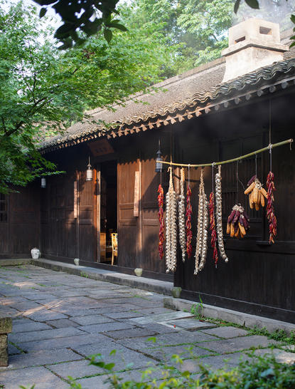 Amanfayun dining venue with dark timber facade and lantern lighting at dusk.