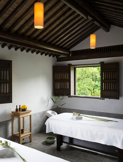 Spa relaxation room at Amanfayun with soaking tub, wooden shutters and pendant lighting.