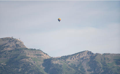 Helicopter flying over forested mountains at Amangani.