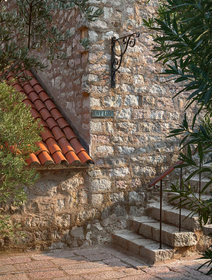 Stone staircase with terracotta roof tiles and climbing ivy at Aman Sveti Stefan.