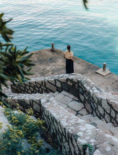 Guests on a stone jetty at Aman Sveti Stefan, with Adriatic Sea views.