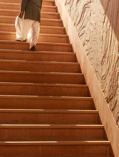Carved wooden staircase with ornate handrail at Amanbagh, traditional Indian architecture detail.