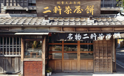 Traditional Japanese storefront with wooden façade and gold signage at Amanemu.