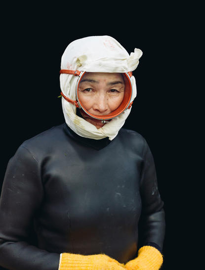 Person wearing traditional white head wrap and black garment at Amanemu.