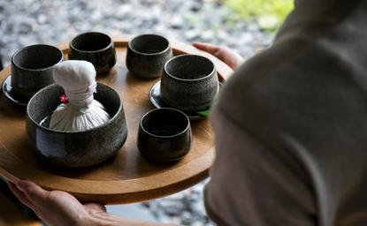 Wellness rituals at Amanemu resort, with traditional vessels arranged on a wooden tray.
