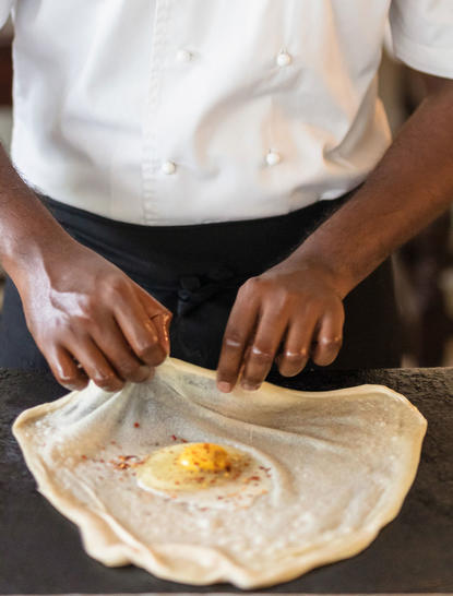 Chef's hands shaping dough at Amangalla dining venue.