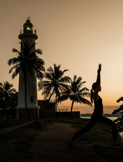 Silhouetted palm trees and historic architecture at Amangalla at dusk.