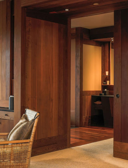 Gros Ventre Suite entrance with warm wooden doors and corridor leading to spa bathroom at Amangani.