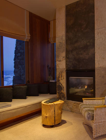 Sena Suite bathroom at Amangani with soaking tub, stone fireplace and evening mountain views.