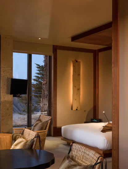 Sena Suite bathroom at Amangani with soaking tub, warm wooden finishes, and mountain views through floor-to-ceiling windows.