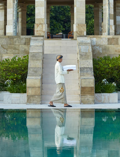 Dalem Jiwo Suite at Amanjiwo with plunge pool and classical stone colonnade reflecting in still water.