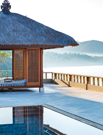 安缦丘澜度假村的套房，配有茅草屋顶和私人泳池，俯瞰海景。