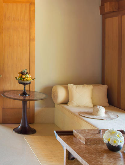 Suite infinity pool area at Amankila resort, with wooden doors, cream cushions and fresh flowers.