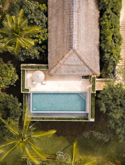 Infinity pool suite with teal water viewed from above at Amankila resort, surrounded by tropical greenery.