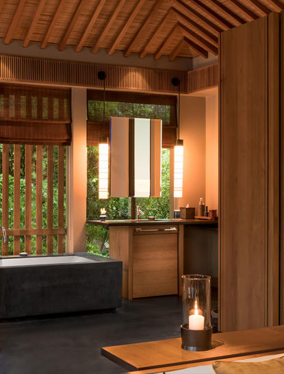 Mountain Pool Villa bathroom at Amanoi with wooden ceiling, soaking tub and illuminated mirror.