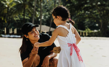 Madre fotografa la figlia sulla spiaggia di Amanpuri resort, Tailandia.