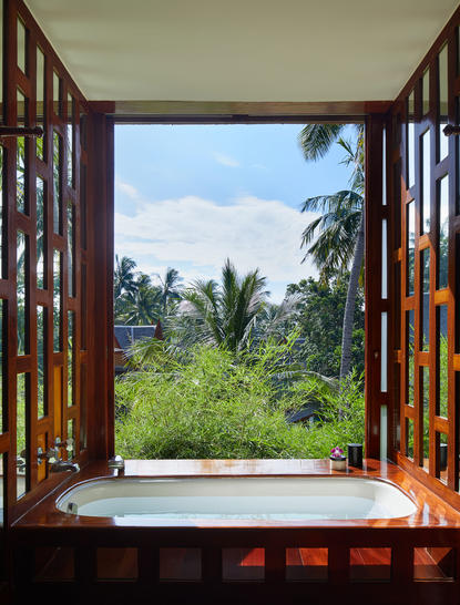 Four-bedroom garden villa at Amanpuri with view of tropical gardens from an open wooden window frame.