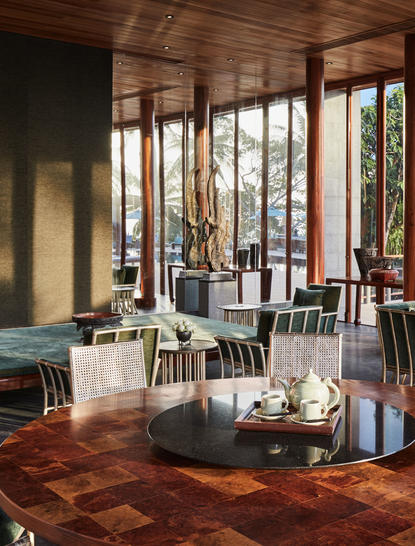 Eight-bedroom ocean villa at Amanpuri with expansive windows, wooden beams, and terracotta flooring overlooking tropical landscape.