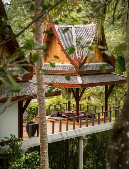 Wooden pavilion amongst trees at Amanpuri resort, with open-sided design and teak railings.