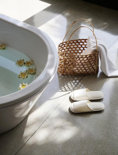 Courtyard Suite bathtub with woven basket and slippers at Amansara.