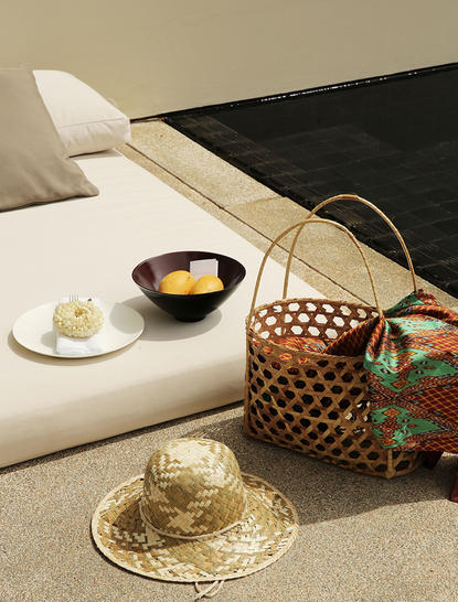 Amansara bedroom detail with woven basket, decorative hat and bedside offerings.
