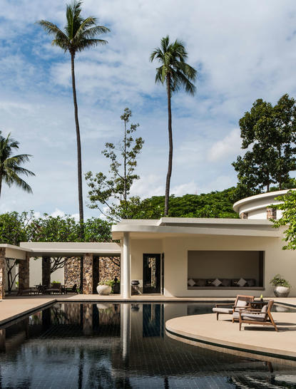 Amansara accommodation pavilion with reflection pool, tropical gardens and palm trees.
