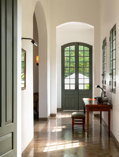 Mekong Pool Suite entrance at Amantaka with arched doorway and wooden desk.