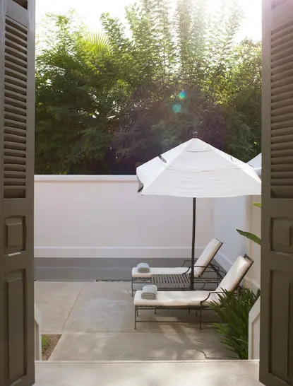 Pool Suite at Amantaka with sunlit garden view and lounge chair on terrace.
