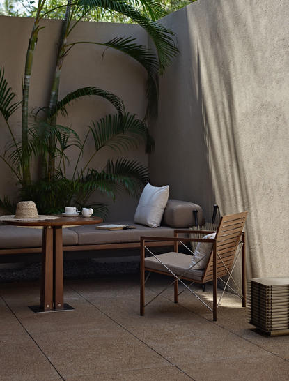 Garden Pool Suite outdoor seating area at Amanwella with wooden furniture and tropical plants.