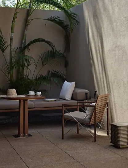 Garden Pool Suite outdoor seating area at Amanwella with wooden furniture and tropical plants.