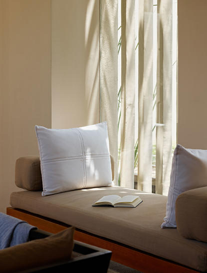 Ocean Pool Suite at Amanwella with white cushion and flowing curtains by window.