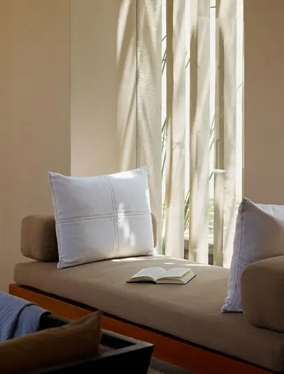 Ocean Pool Suite at Amanwella with white cushion and flowing curtains by window.