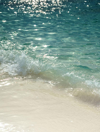 Turquoise waves breaking onto white sand beach at Aman Villas at Nusa Dua.