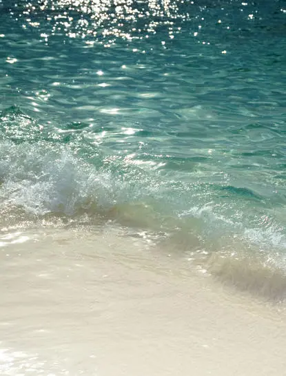 Turquoise waves breaking onto white sand beach at Aman Villas at Nusa Dua.