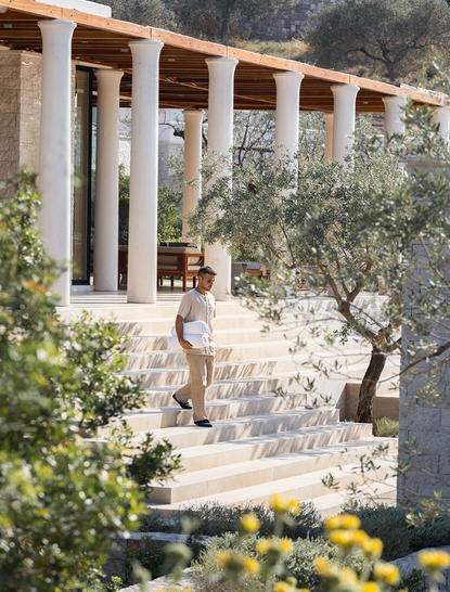 アマンゾイ・リゾートの4ベッドルーム・ヴィラの外観。オリーブの木に囲まれた建築で、柱廊とテラスが特徴。