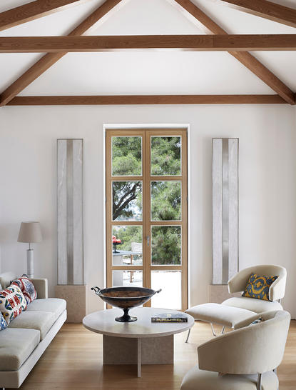 安缦卓熠度假村的单卧室别墅内部,设有木梁天花板、双扇玻璃门和简约家具。
