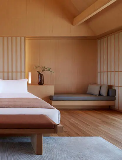 Principal bedroom at Amanemu with wooden platform bed, shoji screens, and minimalist Japanese design.