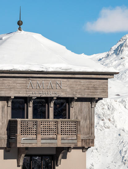 Chambre Nord at Aman Le Mélézin with snow-capped peaks and clear blue sky.