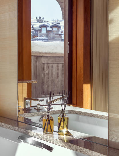 Principal bedroom with views towards the ski piste at Aman Le Mélézin, France.