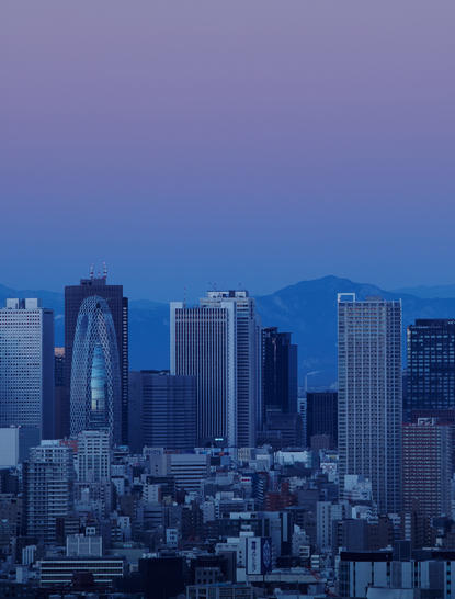 Tokyo's skyline at dusk, with illuminated skyscrapers against a twilight blue sky at Aman Tokyo.