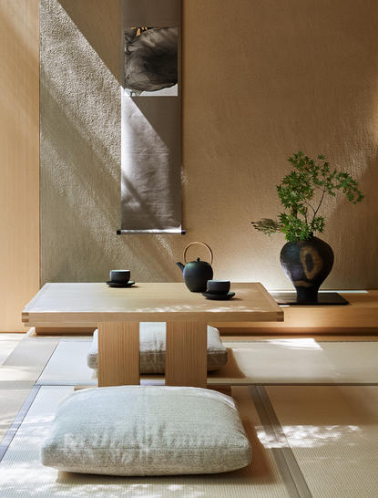 Kaede Room at Aman Kyoto with natural light streaming across wooden furniture and a cushioned floor seat.