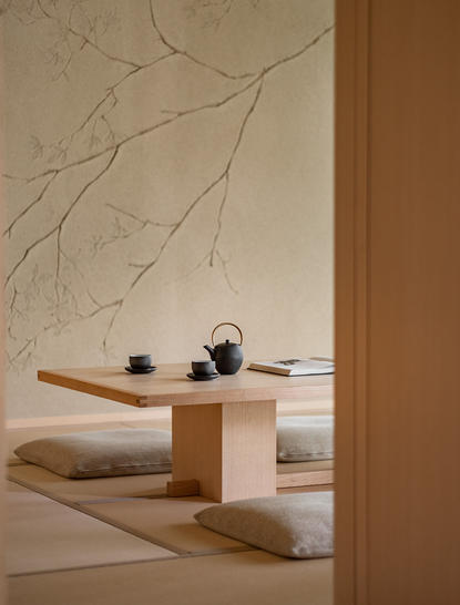 安缦京都度假村的铃木房间内，木制平台上放置着陶制茶具和干枝装饰。