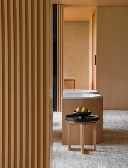 Takagamine Suite bathroom with wooden slat partition and view through to principal bedroom at Aman Kyoto resort.