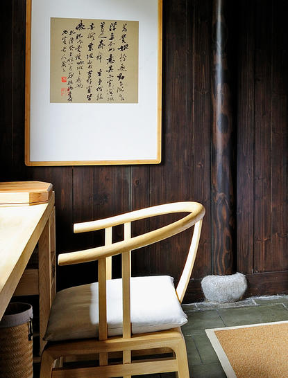 Two-bedroom villa interior at Amanfayun with wooden chair and calligraphy artwork.