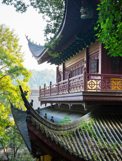 Traditional Chinese pavilion with curved roof and wooden railings at Amanfayun, surrounded by green foliage.